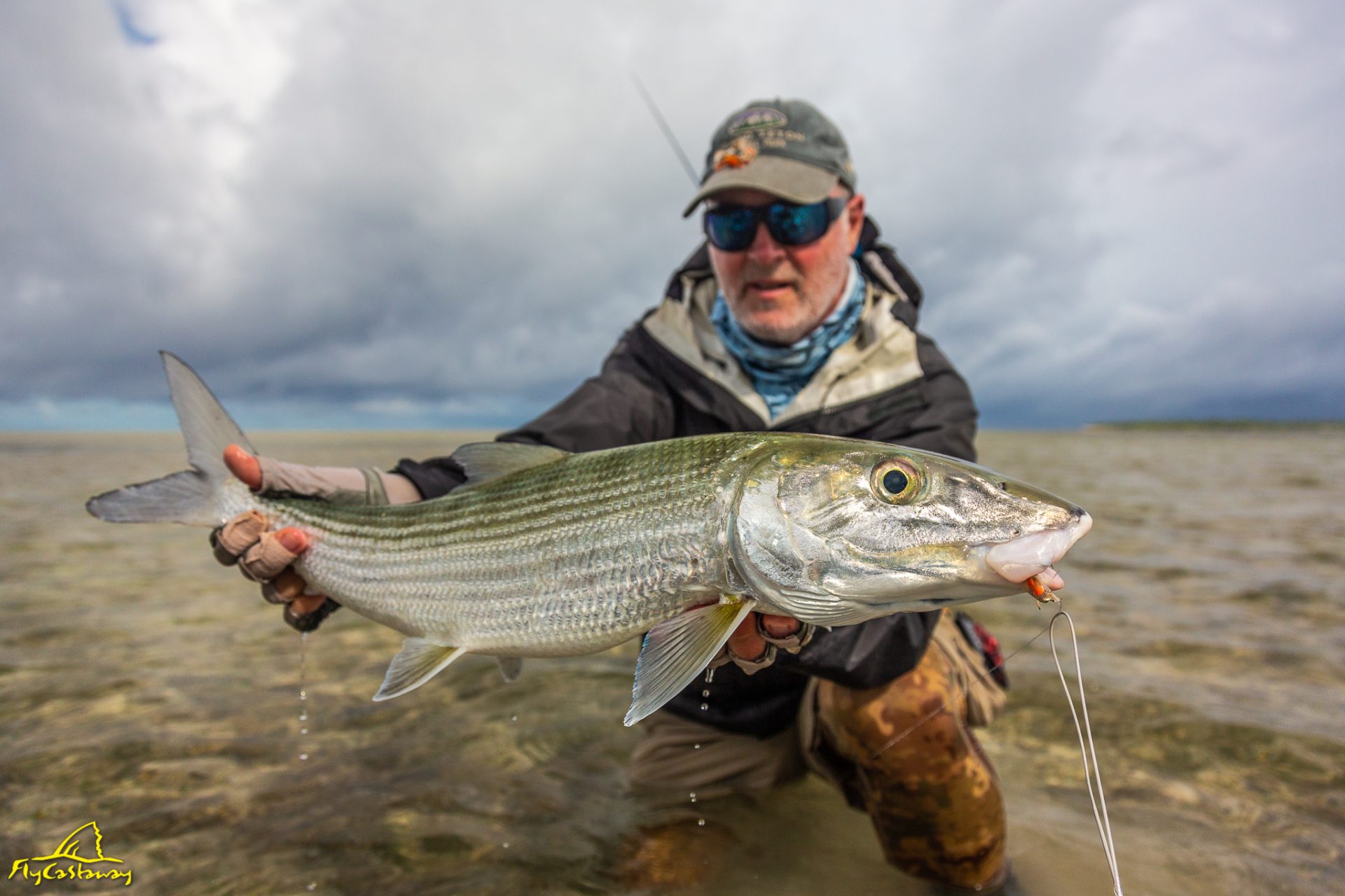 Angler bonefishing in cloudy, rainy conditions with reduced visibility