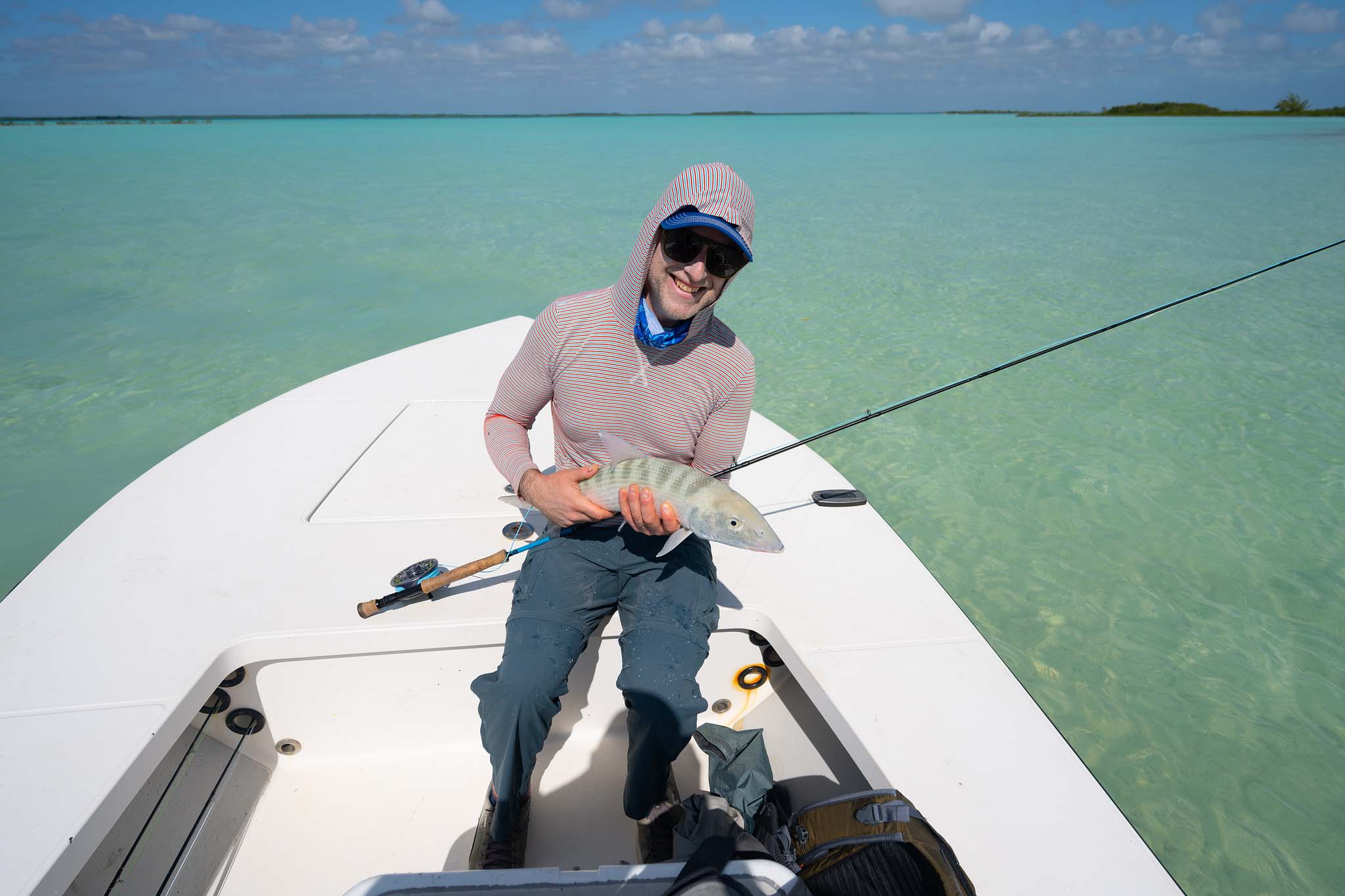 Angler celebrating grand slam catch after hurricane, demonstrating exceptional post-storm fishing success