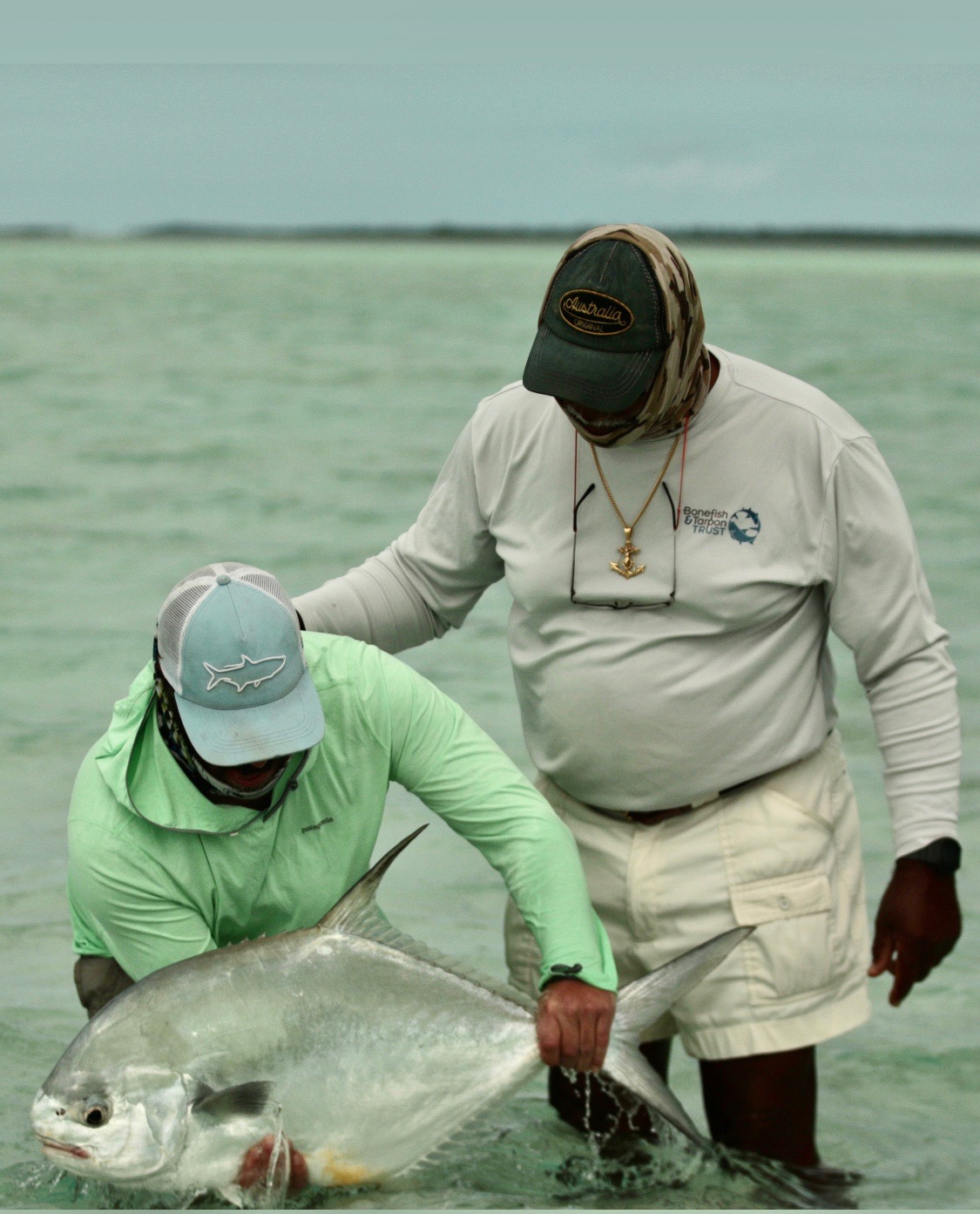 Fly fishing guide and angler working together on Bahamas flat, demonstrating guide expertise in post-hurricane conditions