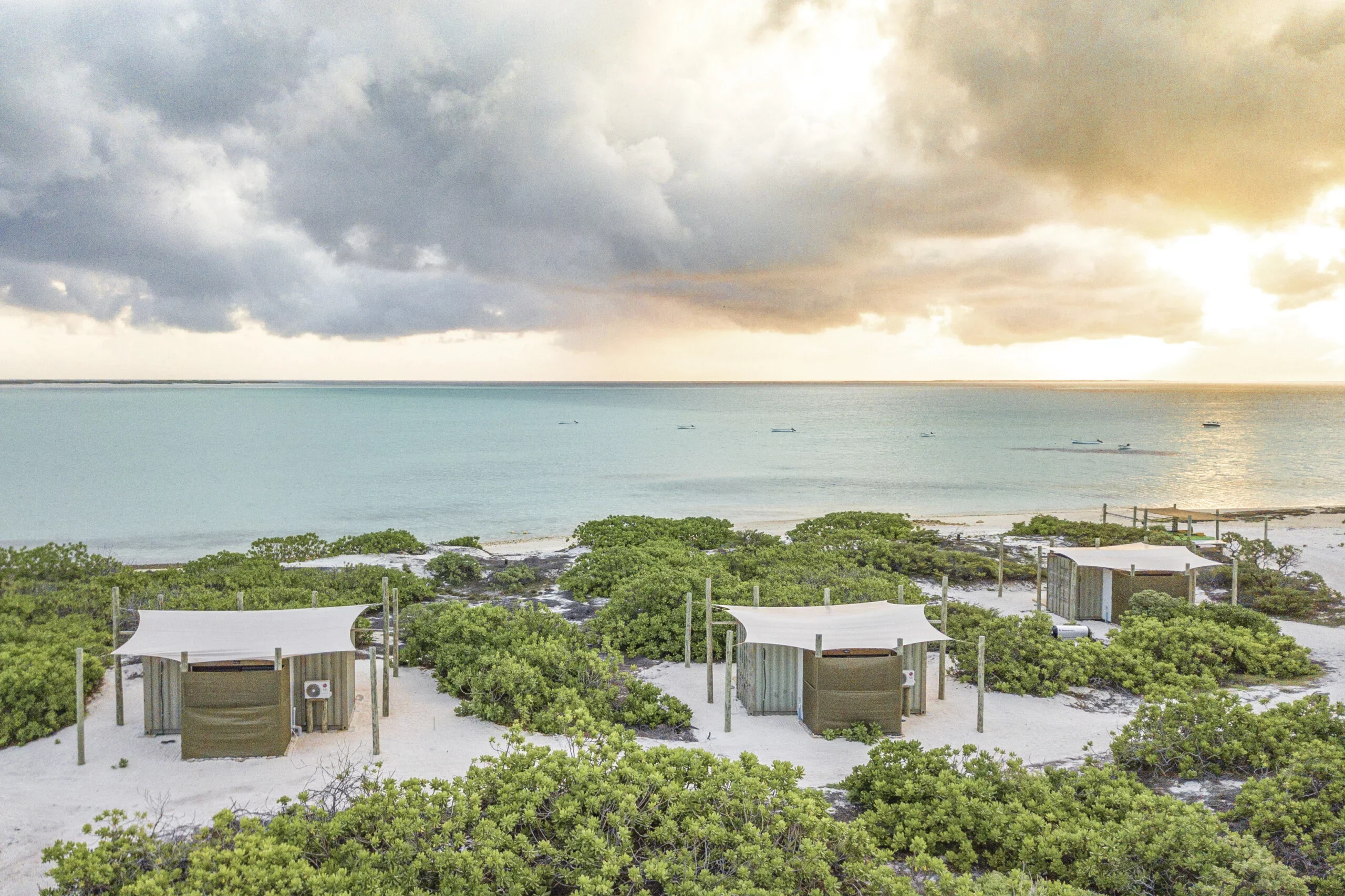 Cosmoledo eco-pods on Wizard Island beach with skiffs, Seychelles