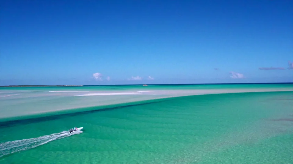 Aerial view of a skiff running the turquoise bonefish flats off Acklins Island near Grey’s Point Inn, Bahamas