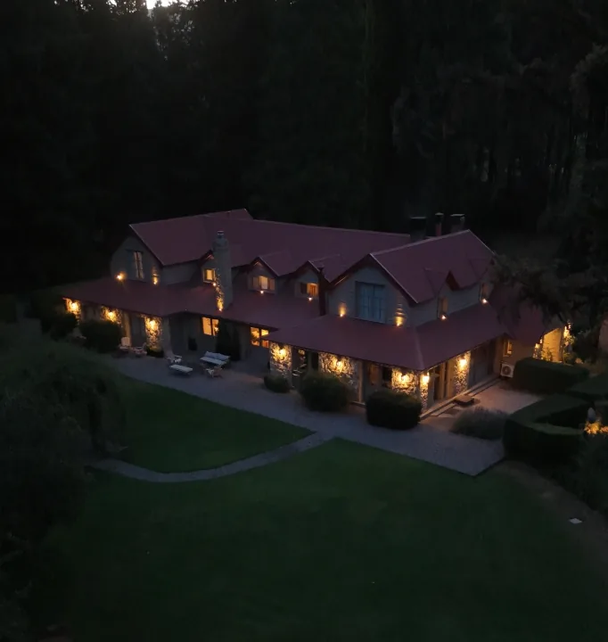 Tipiliuke Lodge at dusk with warm lights in a forest clearing, Patagonia, Argentina