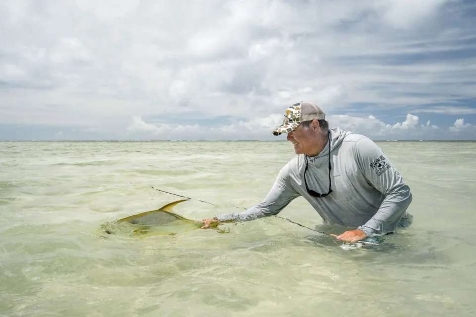 Angler releasing a catch on the flats — Alphonse Island, Seychelles