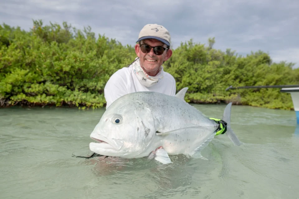 Angler with a giant trevally in the mangroves — Astove Atoll, Seychelles