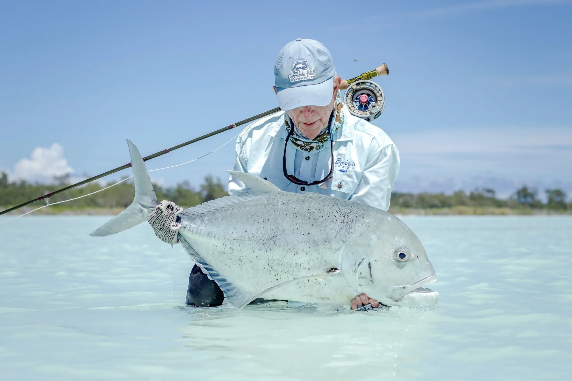 Angler with a giant trevally in the shallows — Astove Atoll, Seychelles