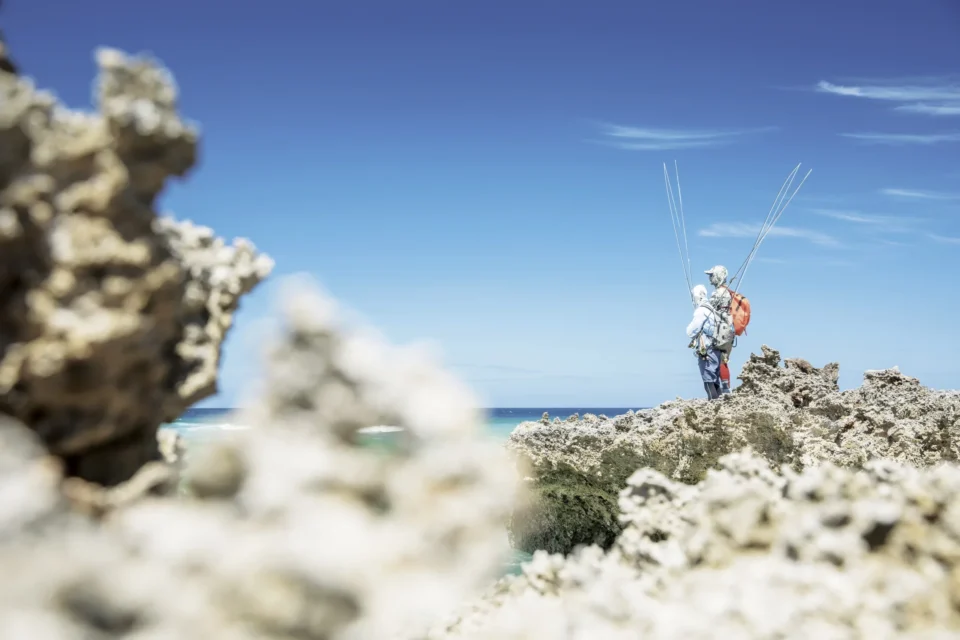 Two anglers scanning the flats from the coral ledge — Astove Atoll, Seychelles
