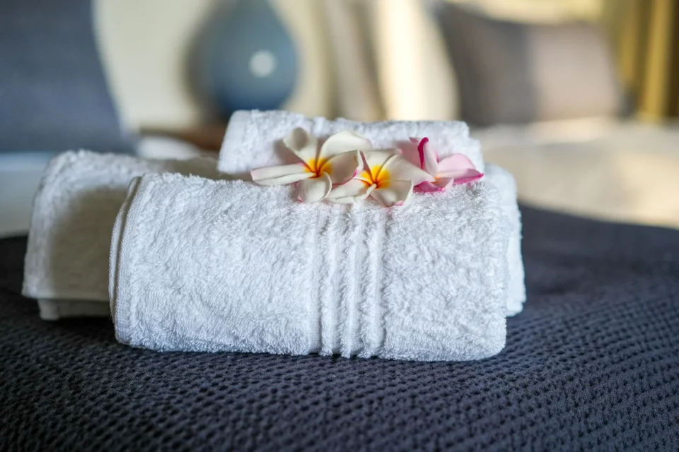 Rolled towels and frangipani on the bed — Farquhar Atoll, Seychelles