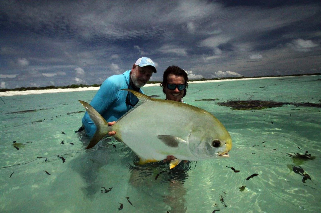 Two anglers with an Indo-Pacific permit — Farquhar Atoll, Seychelles