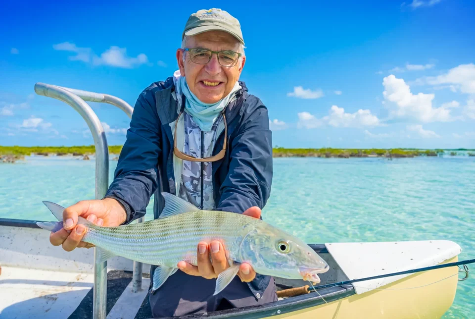 Angler holding a bonefish on a skiff at Mangrove Cay Club, Andros, Bahamas