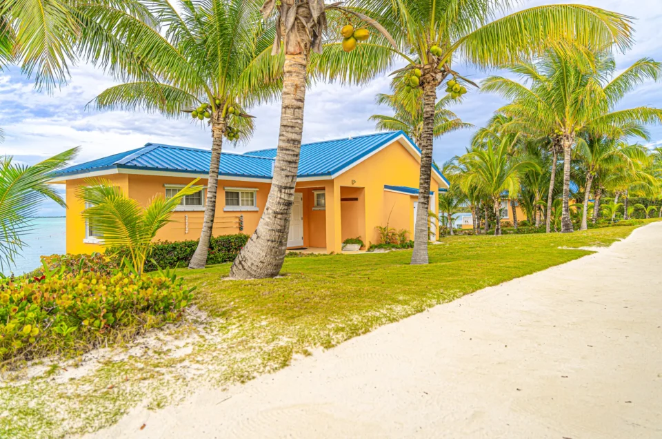Yellow cottage, palms, and sandy path at Mangrove Cay Club, Andros, Bahamas