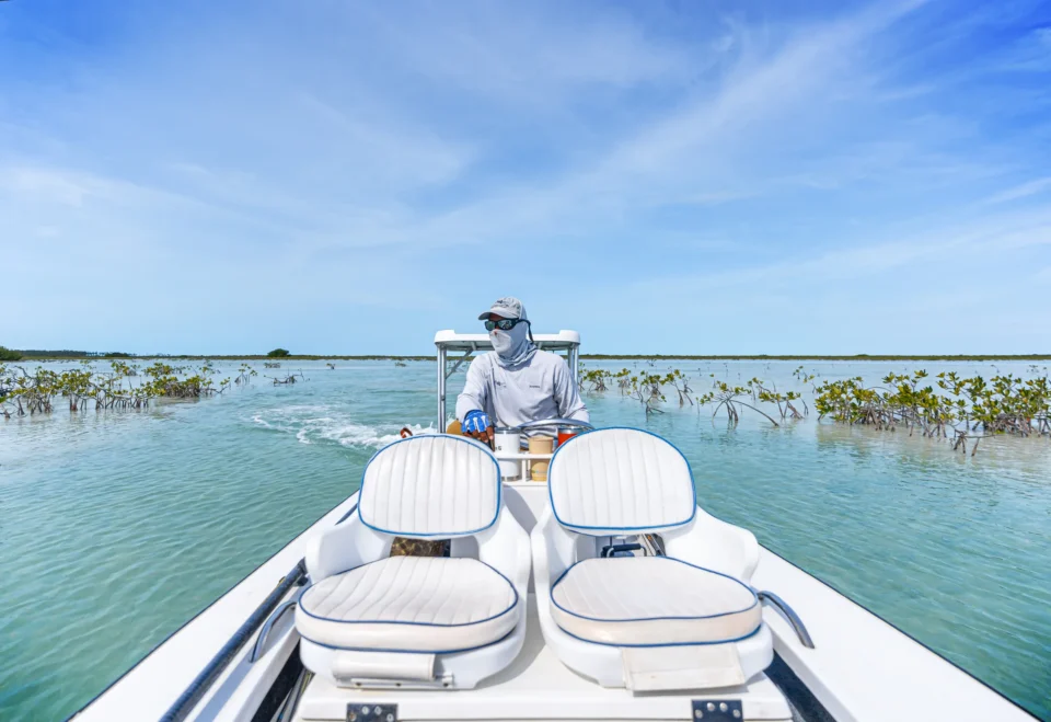 Mangrove Cay Club guide at the helm of a skiff on the Andros flats, Bahamas