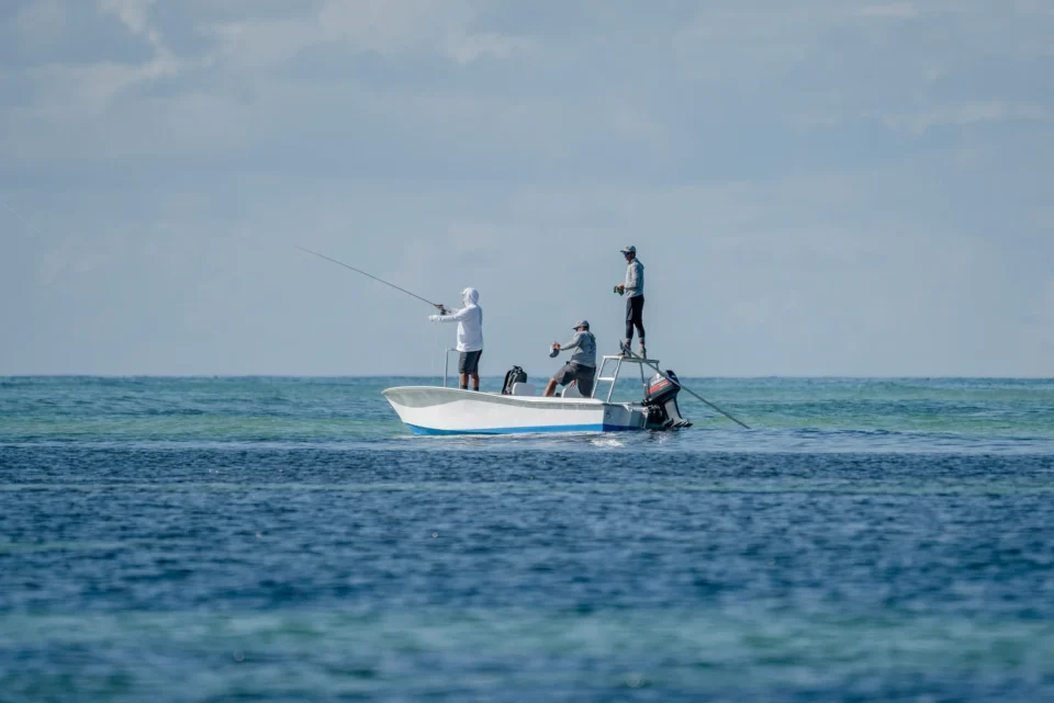 Three anglers on a skiff in the shallows — Providence Atoll, Seychelles
