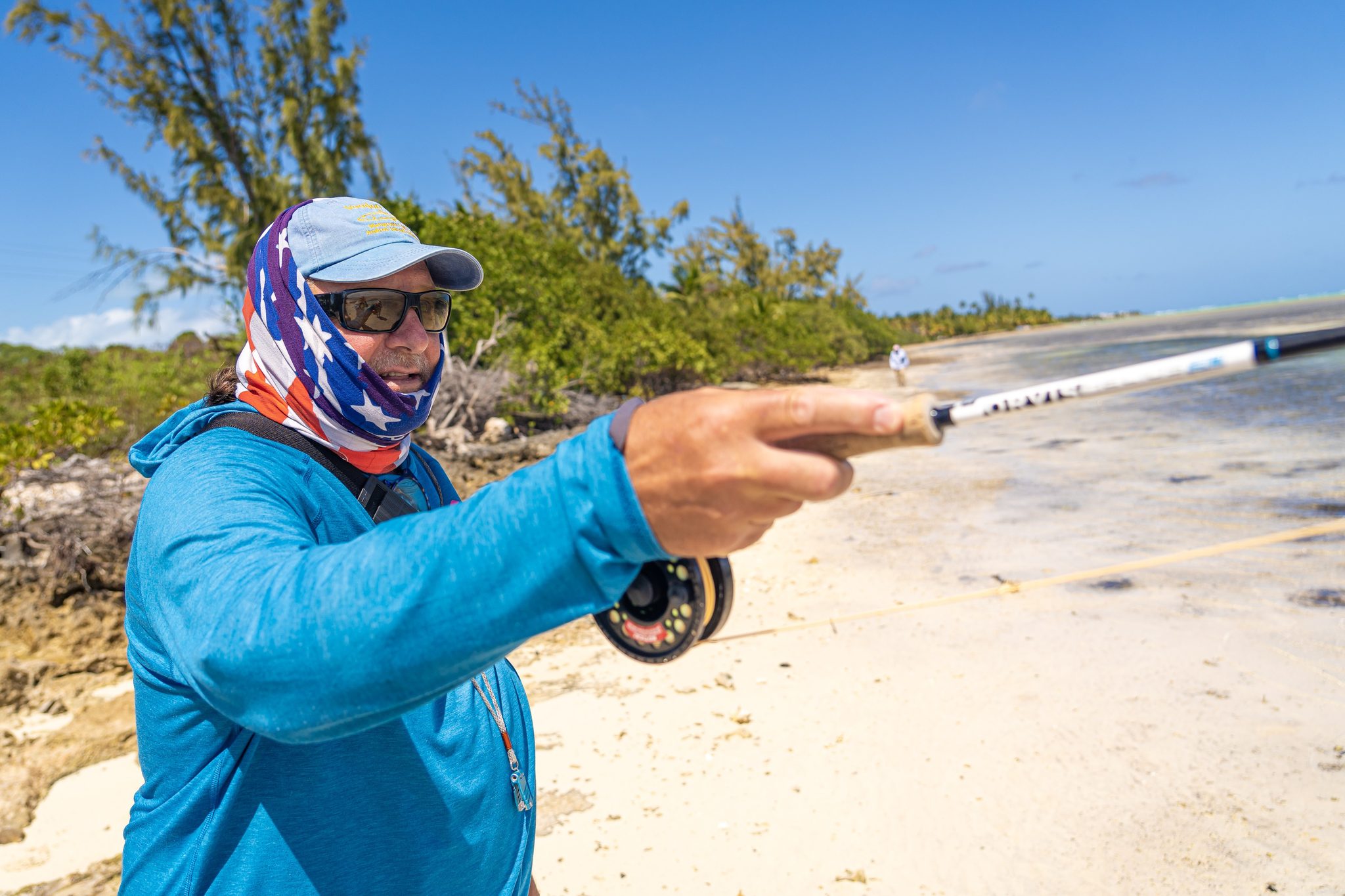 Angler on a Bahamian sandbar, fly rod pointed toward the flats. Photo Adam Campesi, Campesi Design.