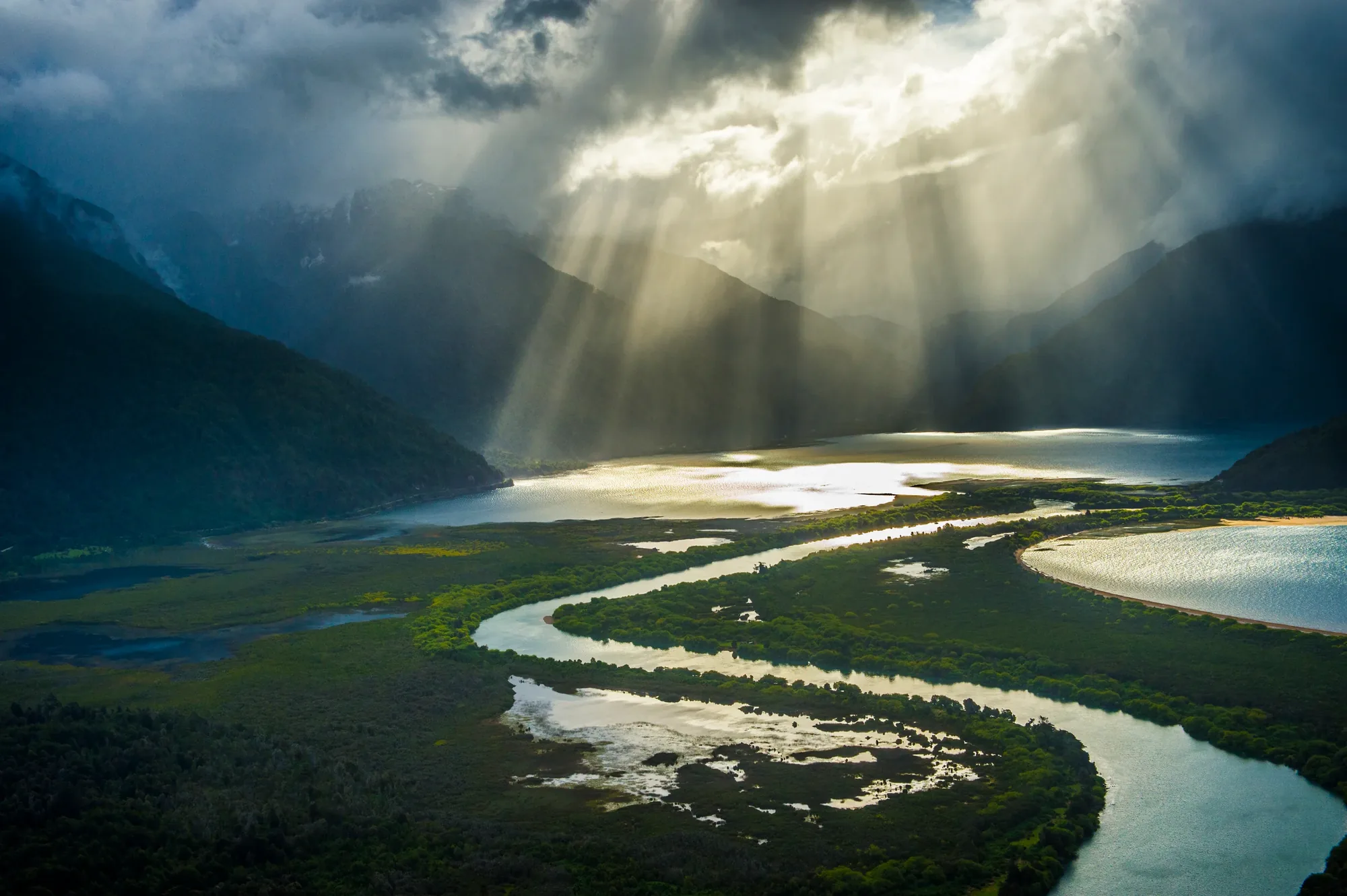 Sunlight over a braided river and lakes in the mountains of northern Chilean Patagonia