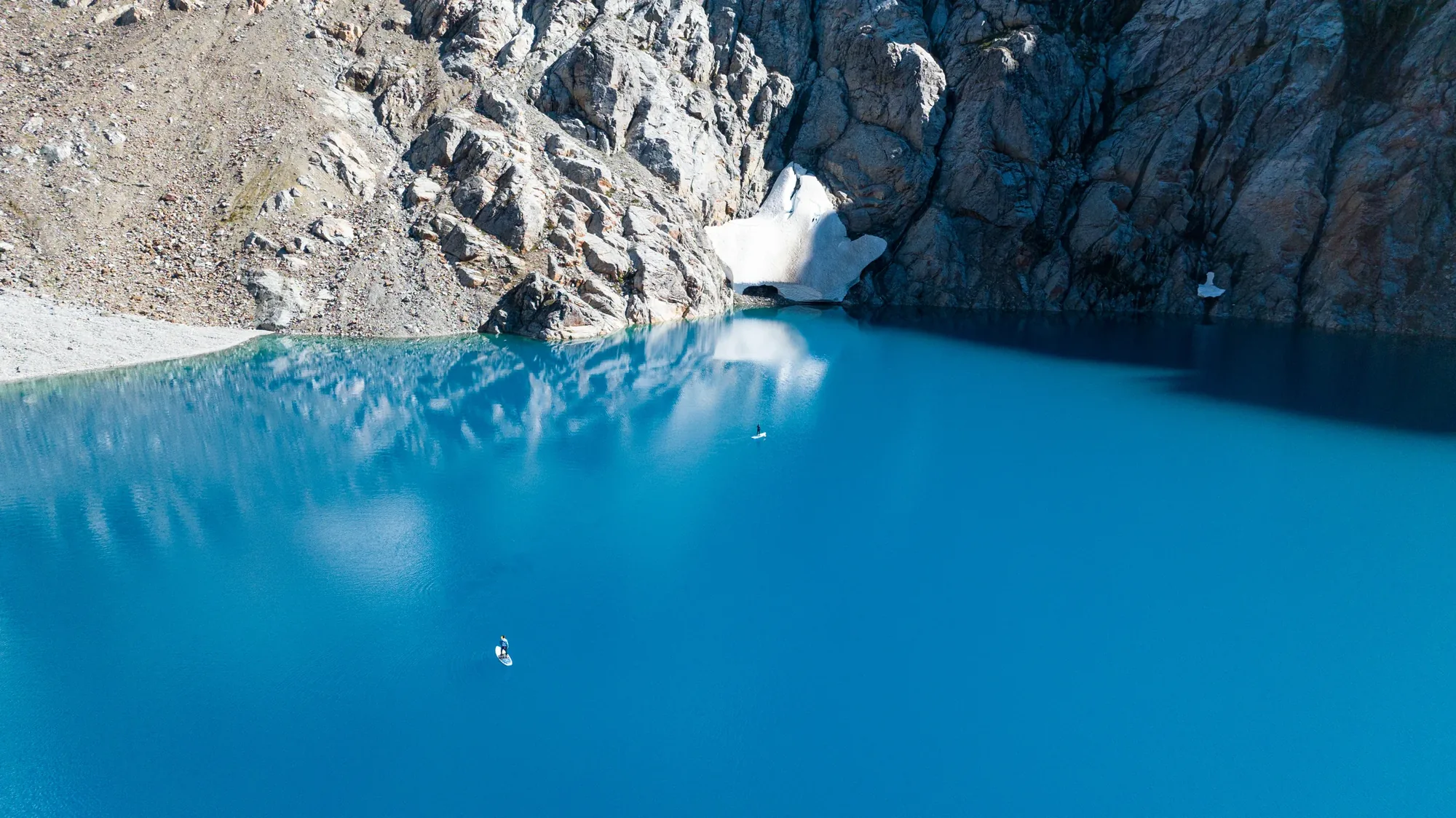 Stand-up paddleboarders on a turquoise glacial lagoon in the Andes, a heli-assisted outing from Rio Palena Lodge, Chile
