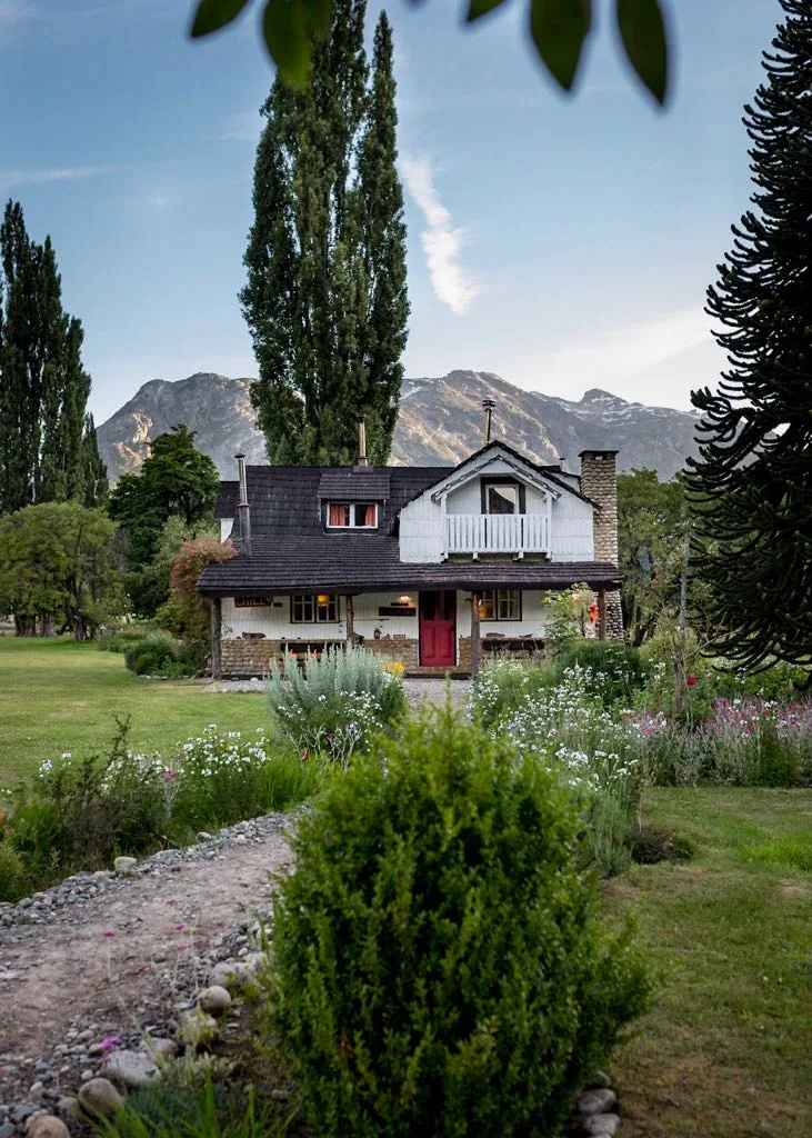 White cottage with a red door at Futa Lodge in the Valle de las Escalas, Chile