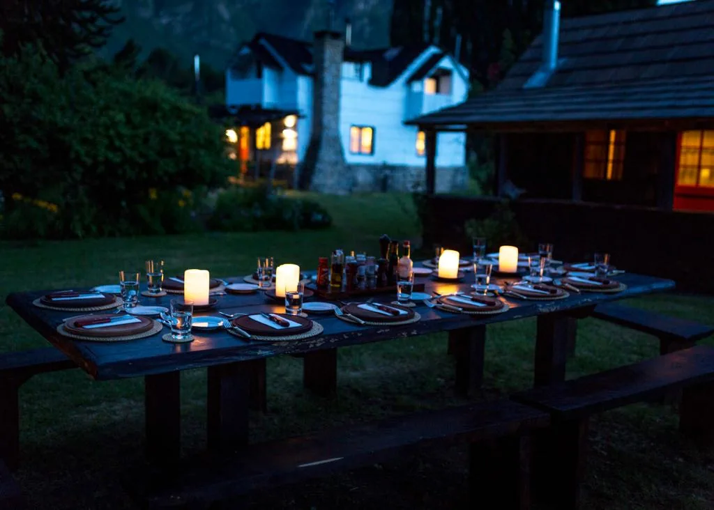 Outdoor dinner table at dusk in front of a cottage at Futa Lodge, Chile