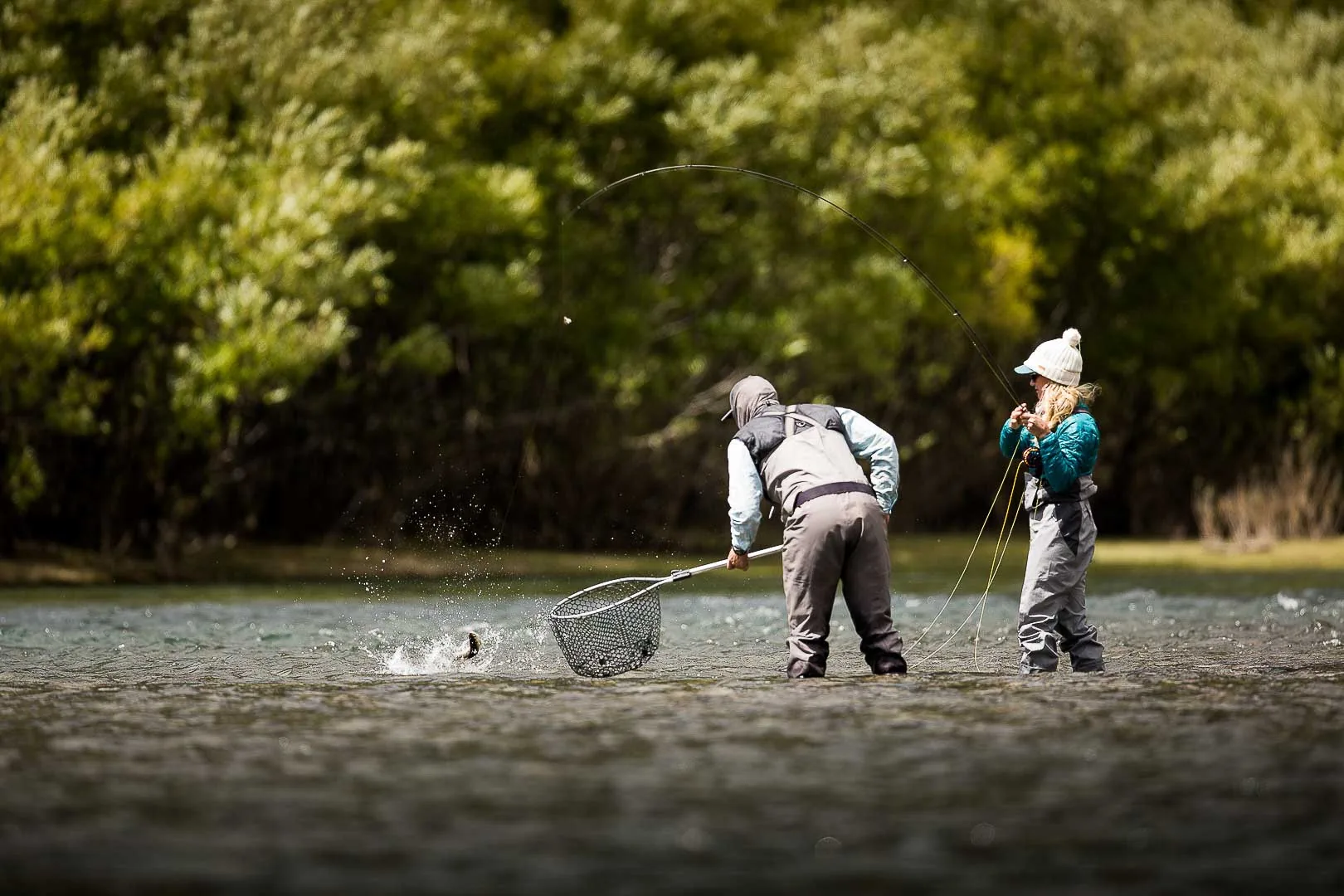 Two anglers netting a trout while wading the Futaleufú River at Futa Lodge, Chile