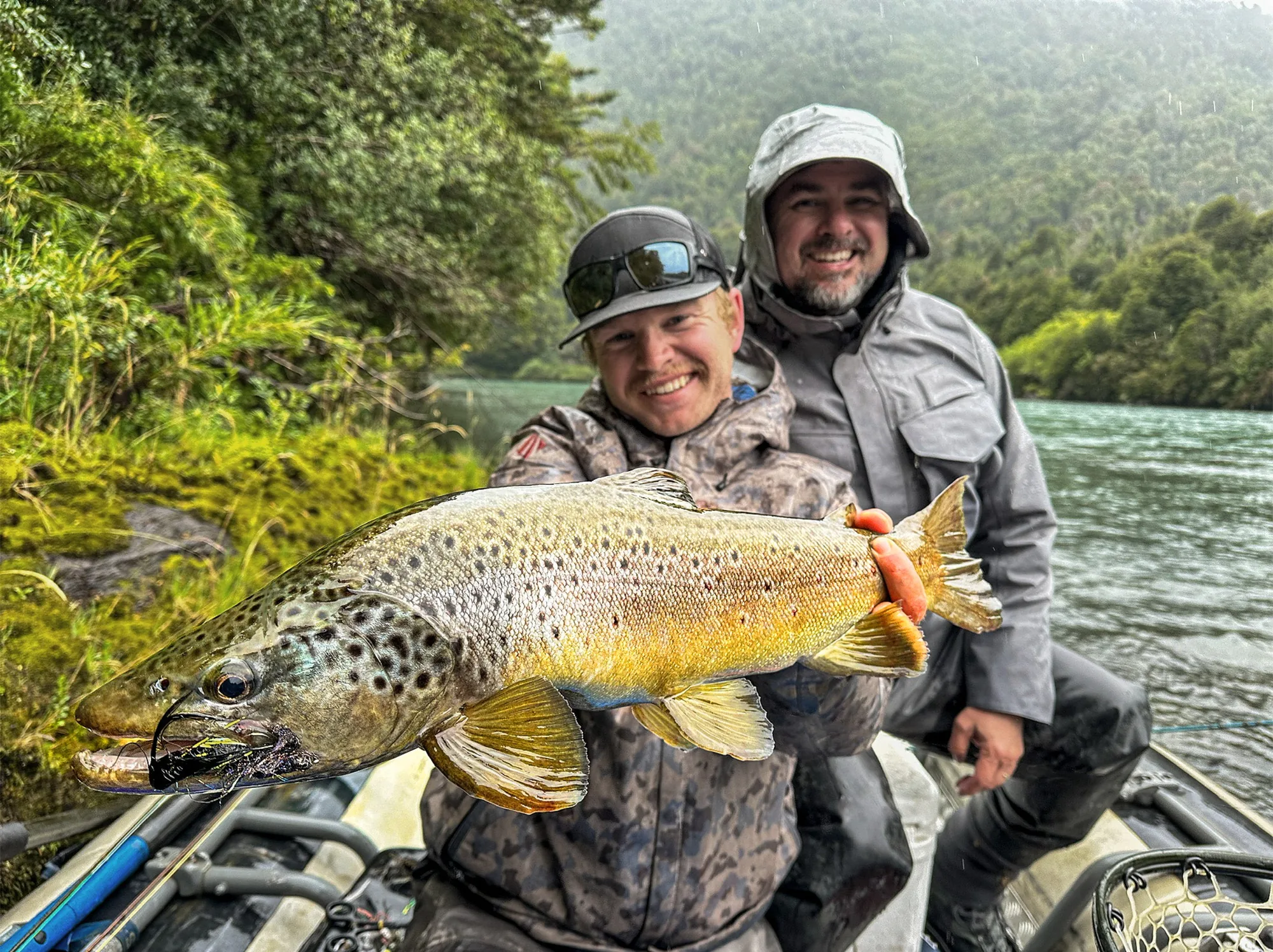 Two anglers in a raft holding a brown trout on a Patagonia river, Eleven Martín Pescador
