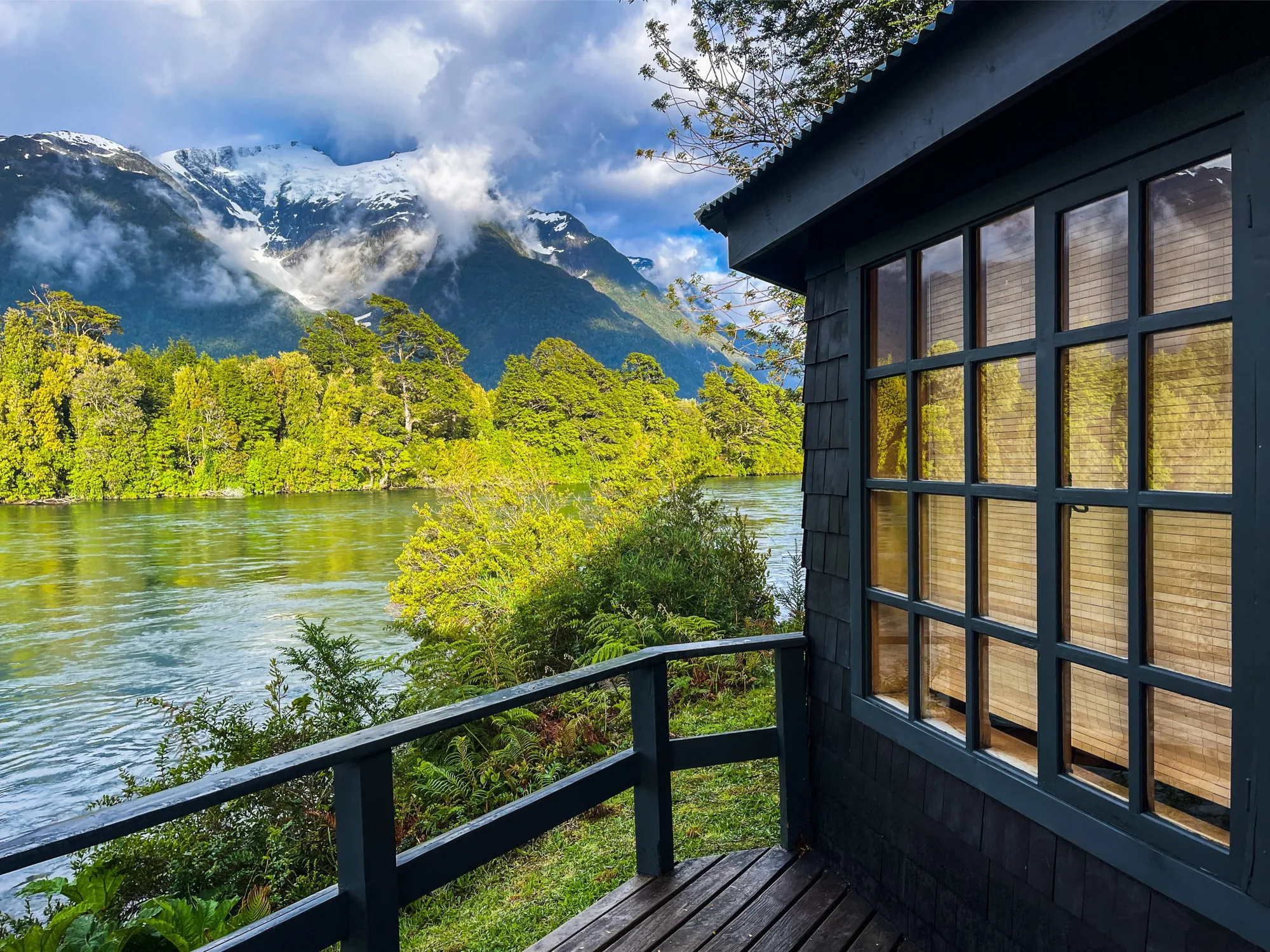 Cabin deck looking across the river to snowy peaks at Eleven Martín Pescador, Chile