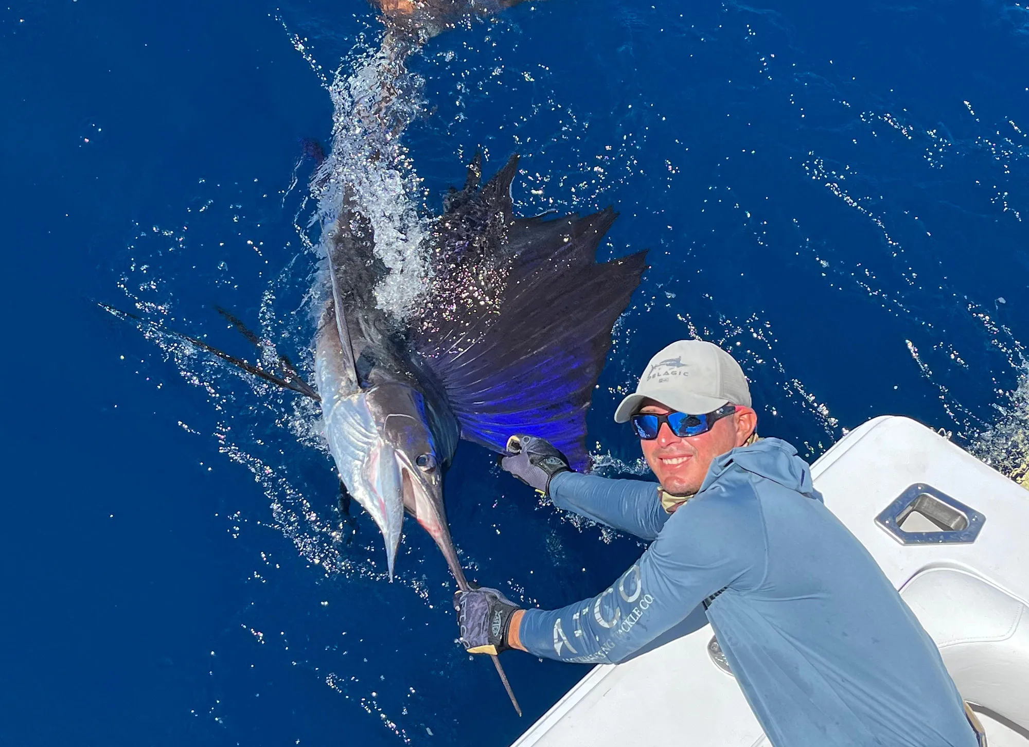 Angler releasing a sailfish beside a Crocodile Bay boat on the Pacific